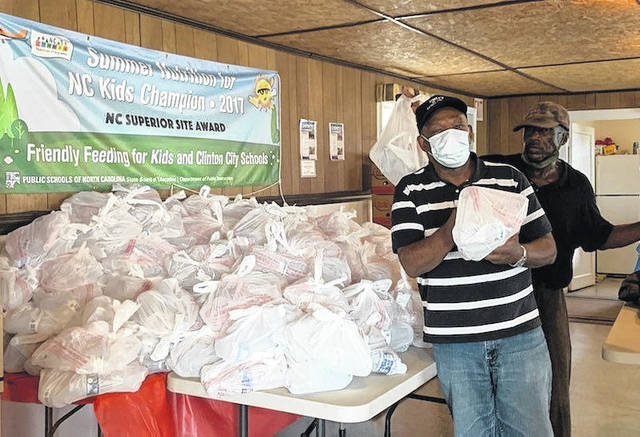 
			
				                                Charles Strickland, left, distributes meals with the help of volunteers.
 
			
		