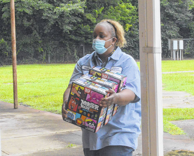 <p>One of the on-call custodians, Sabrina Thomas, lends a hand to bring in the food.</p> <p>Michael B. Hardison | Sampson Independent</p>