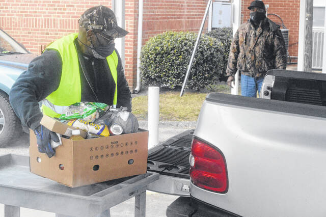 
			
				                                James White loading a truck with one of many food boxes given out at First Baptist Church in a recent drive, during which Mt. Calvary Center for Leadership Development offered assistance.
 
			
		